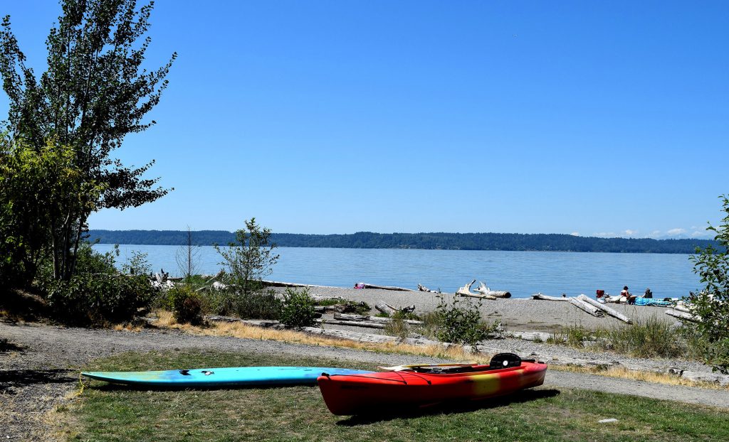 A kayak and a paddleboard on the beach at Seahurst Park in Burien WA